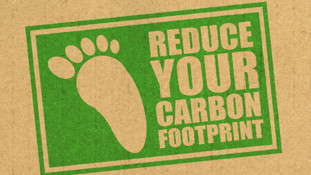 The statement reduce your carbon footprint has been written on a door mat with an illustration of a footmark